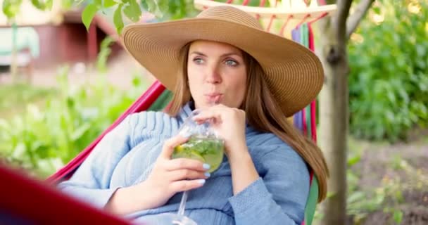 Ung Kvinde Drikker Cocktail Mens Liggende Komfortable Hængekøje Grøn Have – Stock-video