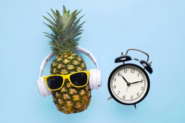 Ananas Met Zonnebril Koptelefoon Met Zwarte Wekker Blauwe Achtergrond — Stockfoto