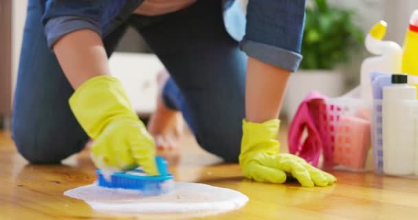 Junge Frau Legerer Kleidung Wäscht Holzboden Mit Fußbodenbürste Erledigt Hausaufgaben — Stockvideo