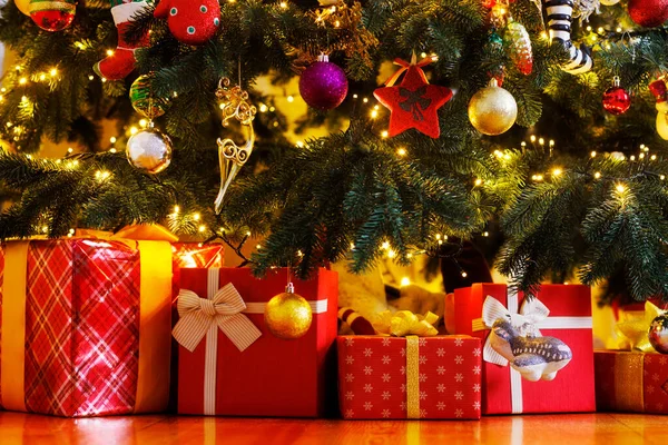 在漂亮的圣诞树下的地板上堆满了圣诞礼品盒 — 图库照片