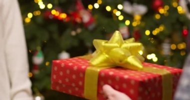 Erkek eller hediyelerini hediye paketi kağıdıyla kadın ellerine veriyor. Aile tatili kavramı, mükemmel Noel kavramı, yeni yıl. Yüksek kalite 4k görüntü