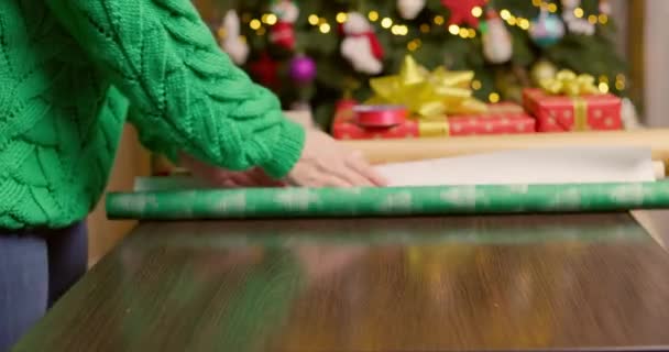 若い女性はクリスマスの準備をし 贈り物を包む お祝いのための贈り物の包装と準備 高品質4K映像 — ストック動画