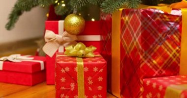 Bir kadının elleri Noel ağacının altından hediye kutusunu çeker. Noel ağacı, mutlu tatiller. Tatil ve Hediye kavramı. Yüksek kalite 4k görüntü
