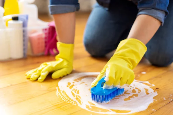 stock image Woman in rubber gloves is using floor brush to cleaning floor. Housekeeping and cleaning concept.