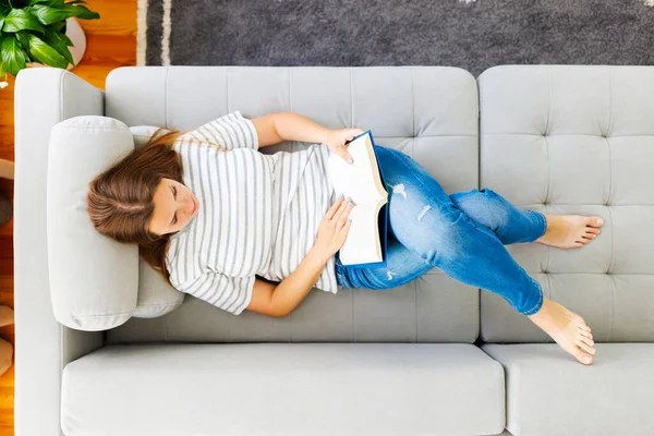Genç Esmer Kadının Kanepede Dinlenmesi Evde Kitap Okuması — Stok fotoğraf