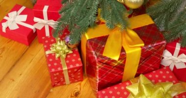 Bir kadının elleri Noel ağacının altından hediye kutusunu çeker. Noel ağacı, mutlu tatiller. Tatil ve Hediye kavramı. Yüksek kalite 4k görüntü