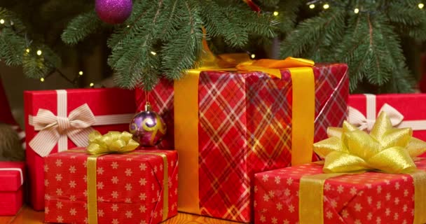 圣诞礼品盒堆在美丽的圣诞树下的地板上 高质量的4K镜头 — 图库视频影像