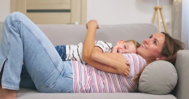 Mor Omfavner Kysser Sin Søde Lille Søn Mens Ligger Sammen – Stock-video