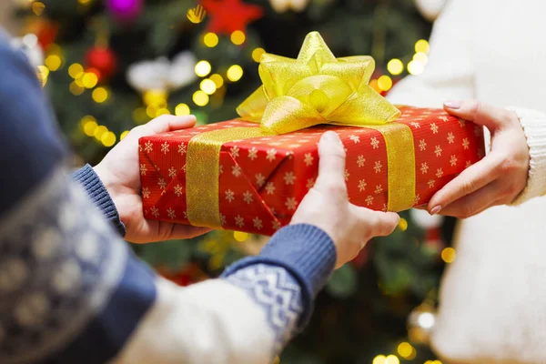 男性の手は女性の手にクリスマスの包むペーパーでプレゼントを与えます 家族の休日のコンセプト 完璧なクリスマス — ストック写真