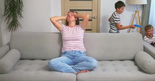 Stresli Genç Anne Koltukta Oturuyor Gürültülü Gürültüden Bıkmış Küçük Kardeşler — Stok video