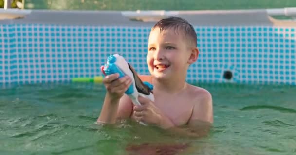 子供は晴れた夏の日のプールで水銃で遊び プールを楽しんでいます 高品質の4K映像 — ストック動画