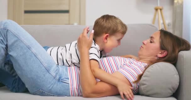 어머니는 거실에서 소파에 누워있는 포옹과 그녀의 귀여운 아들에게 고품질 — 비디오
