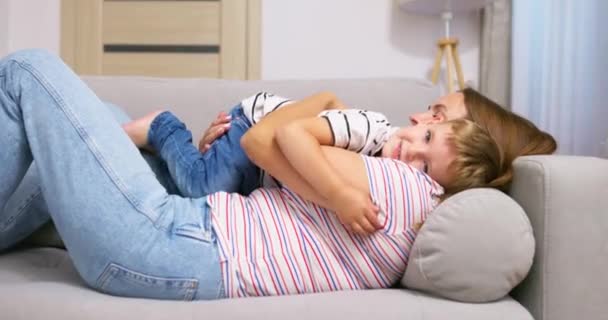Mor Omfavner Kysser Sin Søde Lille Søn Mens Ligger Sammen – Stock-video