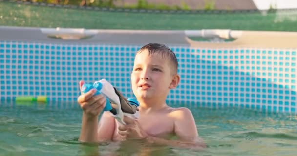 子供は晴れた夏の日のプールで水銃で遊び プールを楽しんでいます 高品質の4K映像 — ストック動画