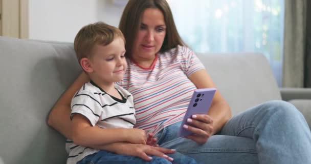 Kadın Küçük Oğlu Akıllı Telefonlu Rahat Koltukta Oturuyorlar Aileler Evde — Stok video