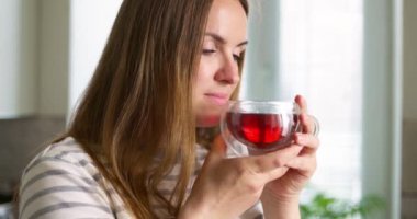 Düşünceli, sakin, çay ya da kahve içen, huzurlu, kaygısız bir sabah vaktinin keyfini çıkaran, geleceği planlayan ya da evde dinlenen bir kadın. Yüksek kalite 4k görüntü