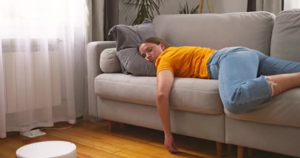 Mujer Muy Cansada Durmiendo Sofá Casa Mientras Robot Aspirador Trabajando — Vídeos de Stock