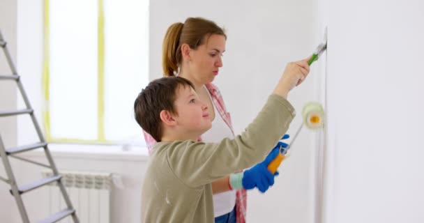 快乐的家庭母亲和孩子们用胶辊和刷子在墙上作画 在公寓里修理 高质量的4K镜头 — 图库视频影像