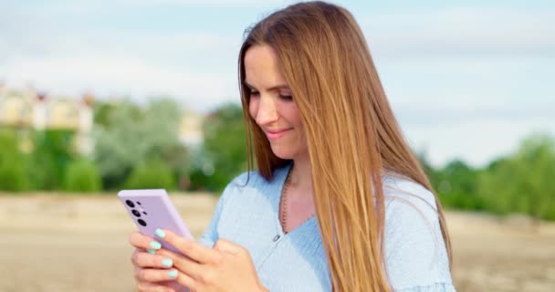 女性テキストメッセージ ソーシャルネットワーク上の投稿 レビューを書いたり コメントしたり 屋外でスマートフォンを使用してインターネットを閲覧したりします 高品質の4K映像 — ストック動画