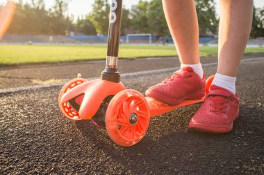 Küçük çocuk mobilete biniyor. Mevsimlik çocuk aktivitesi sporu. Sağlıklı açık hava aktivitesi. Çocuklar için aktif eğlence ve açık hava sporu.