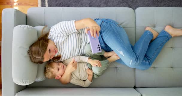 Kobieta Jej Synek Leżą Wygodnej Sofie Smartfonem Nad Widokiem Rodzina — Wideo stockowe