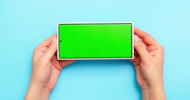 Ženy Ruce Drží Smartphone Zelenou Obrazovkou Modrém Pozadí Vysoce Kvalitní — Stock video