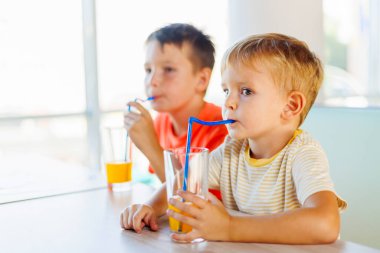 Tatlı çocuklar fast food restoranında soda ya da samanla meşrubat içiyorlar..