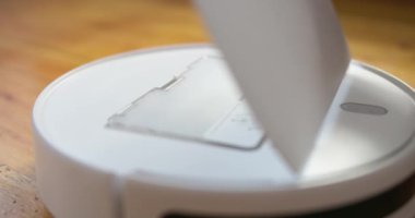 Yakın çekim eller, temizlikten sonra robot elektrik süpürgesinin tozuyla dolu bir konteynırı temizler. Temizlikten sonra robot elektrik süpürgesini temizliyorum. Yüksek kalite 4k görüntü