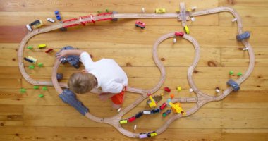 Evde ya da anaokulunda oyuncak ahşap demiryollarıyla oynayan sevimli bir çocuk. Ahşap eğitici oyuncaklar. Üst Manzara. Yüksek kalite 4k görüntü