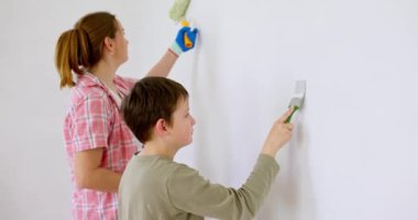 Mutlu bir aile babası ve çocuğu. Duvarı silindir ve fırçayla boyuyor. Apartmanda tamirat var. Yüksek kalite 4k görüntü
