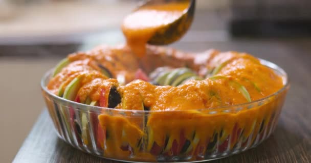 ガラスボウルにスライスした野菜をソースで注ぎます ラタトゥイユ料理の調理準備 高品質の4K映像 — ストック動画