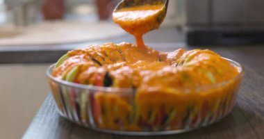 Cam kasede dilimlenmiş sebzeler sosla doldurulur. Ratatouille yemek hazırlığı. Yüksek kalite 4k görüntü
