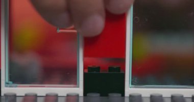 Renkli plastik tuğlalarla oynayan ve inşa eden çocukların yakın çekimi. Erken öğrenme ve geliştirme