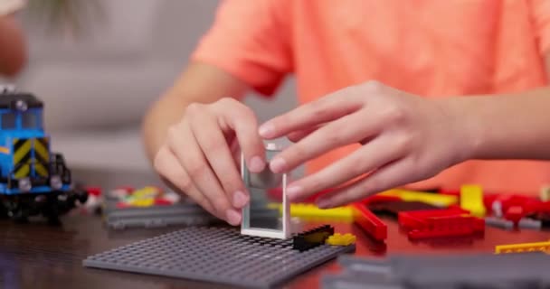 Menino Brincando Construindo Com Tijolos Plásticos Coloridos Mesa Aprendizagem Precoce — Vídeo de Stock