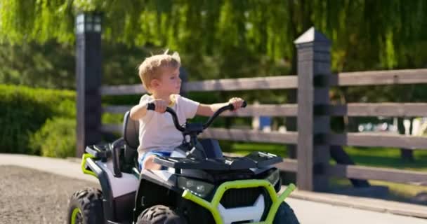 Uma Criança Dirigindo Carro Elétrico Brinquedo Parque Dia Verão Rapaz — Vídeo de Stock