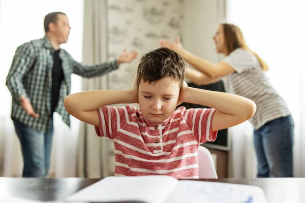 Ebeveynler Arasında Üzgün Bir Çocuğun Önünde Elleriyle Kulaklarını Kapatan Bir Telifsiz Stok Imajlar