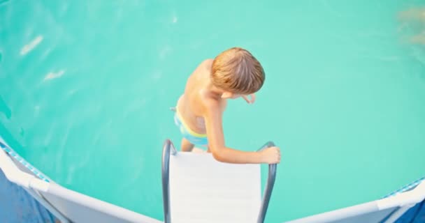 Радостный Мальчик Прыгает Бассейн Наслаждается Плаванием Бассейне Наслаждаясь Летним Отпуском — стоковое видео