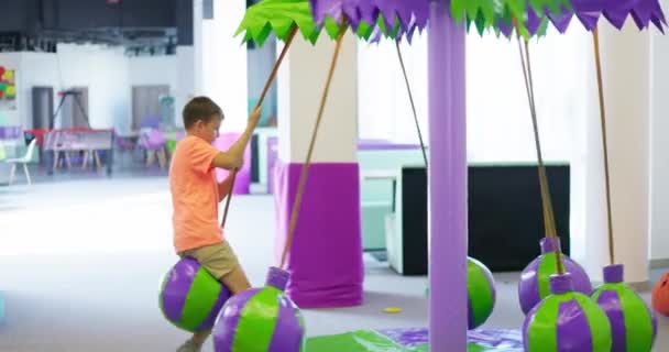 소년은 어린이 엔터테인먼트 센터에서 목마를 놀이터 놀이터에서 활동적인 어린이 고품질 — 비디오
