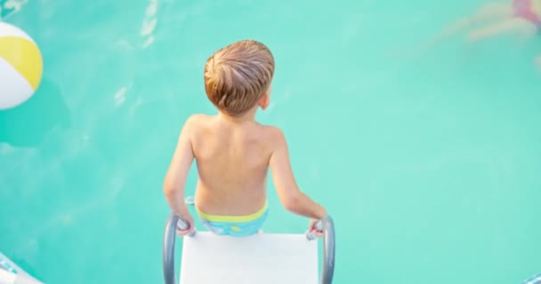 Χαρούμενο Αγόρι Που Πηδάει Στην Πισίνα Απολαμβάνει Κολύμπι Στην Πισίνα — Αρχείο Βίντεο