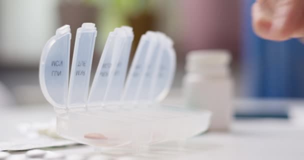 オープンピルオーガナイザーやプラスチック製のピルボックスに丸薬を入れる男性の手 医師の処方に従って毎日の使用のための錠剤のソート — ストック動画