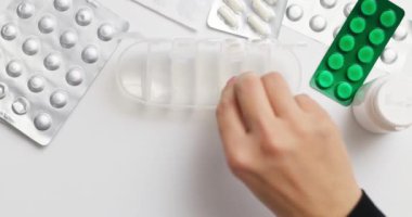 Kadın hapları açık ilaç organizatörüne ya da plastik ilaç kutusuna koyuyor. Doktorların reçetesine göre günlük kullanım için tabletlerin sıralanması