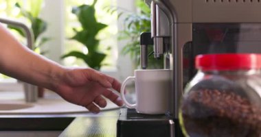 Erkek el mutfaktaki kahve makinesinin hazırladığı bir fincan kahveyi alıyor. Kahvaltıda içecek. Yüksek kalite 4k görüntü