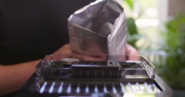 Kahve yapmak için kahve makinesine kahve çekirdeği döken bir adam. Yüksek kalite 4k görüntü