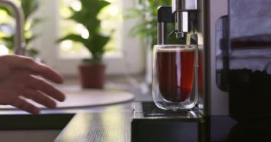 Erkek el mutfaktaki kahve makinesinin hazırladığı bir fincan kahveyi alıyor. Kahvaltıda içecek. Yüksek kalite 4k görüntü