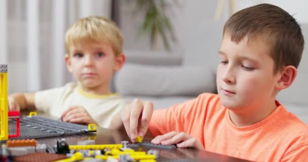 Duas Crianças Brincando Construindo Com Tijolos Plásticos Coloridos Mesa Aprendizagem — Vídeo de Stock