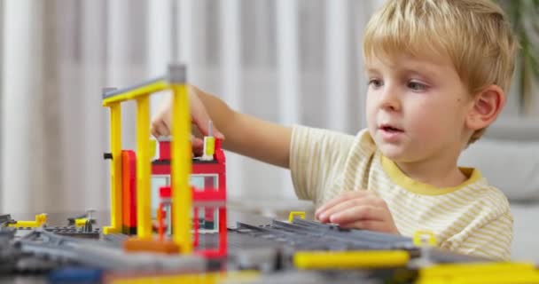 Chłopiec Bawi Się Buduje Kolorowymi Plastikowymi Cegłami Przy Stole Wczesne — Wideo stockowe