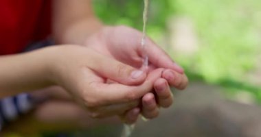 Childs 'ın elleri musluktan su toplar, temiz su musluktan ellere akar. Yüksek kalite 4k görüntü