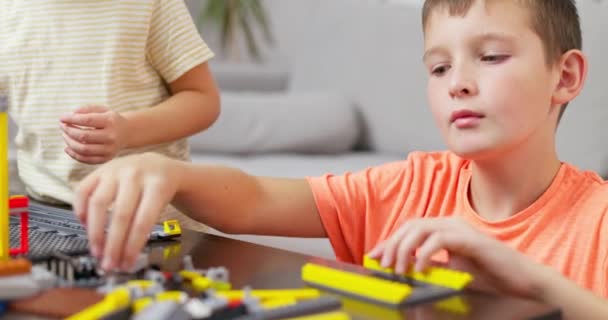 Двое Детей Играют Строят Разноцветными Пластиковыми Кирпичами Столом Раннее Обучение — стоковое видео