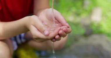 Childs 'ın elleri musluktan su toplar, temiz su musluktan ellere akar. Yüksek kalite 4k görüntü