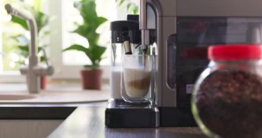 Kahve makinesi kapuçino ya da latte hazırlamak için bir bardak sütlü kahve bardağına espresso koyar. Yüksek kalite 4k görüntü
